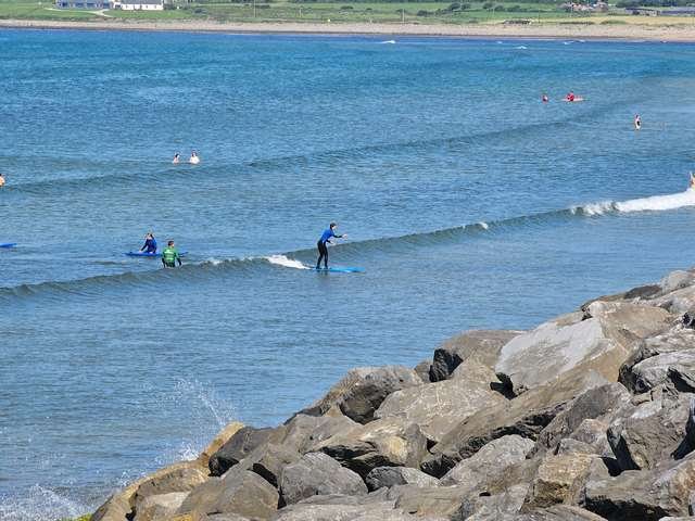 Beginner surfer riding a wave in the shallows 